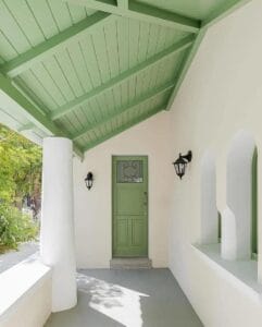 Exterior of a Sarasota home with freshly painted green wood ceilings by Gulf Coast Painting SRQ, showcasing professional power washing and exterior painting services.