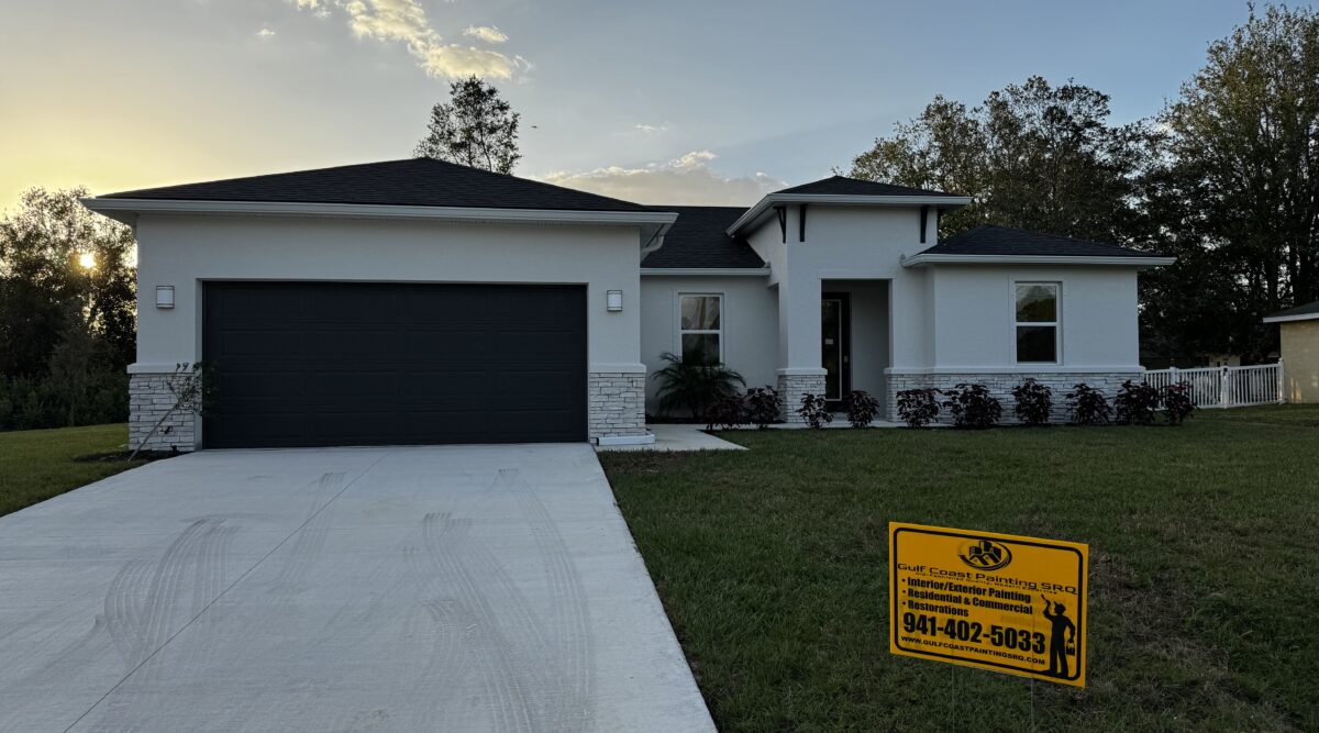 Sunlit exterior of a renovated Venice, Florida home with a modern white paint job and white accents, emphasizing high-quality painting work