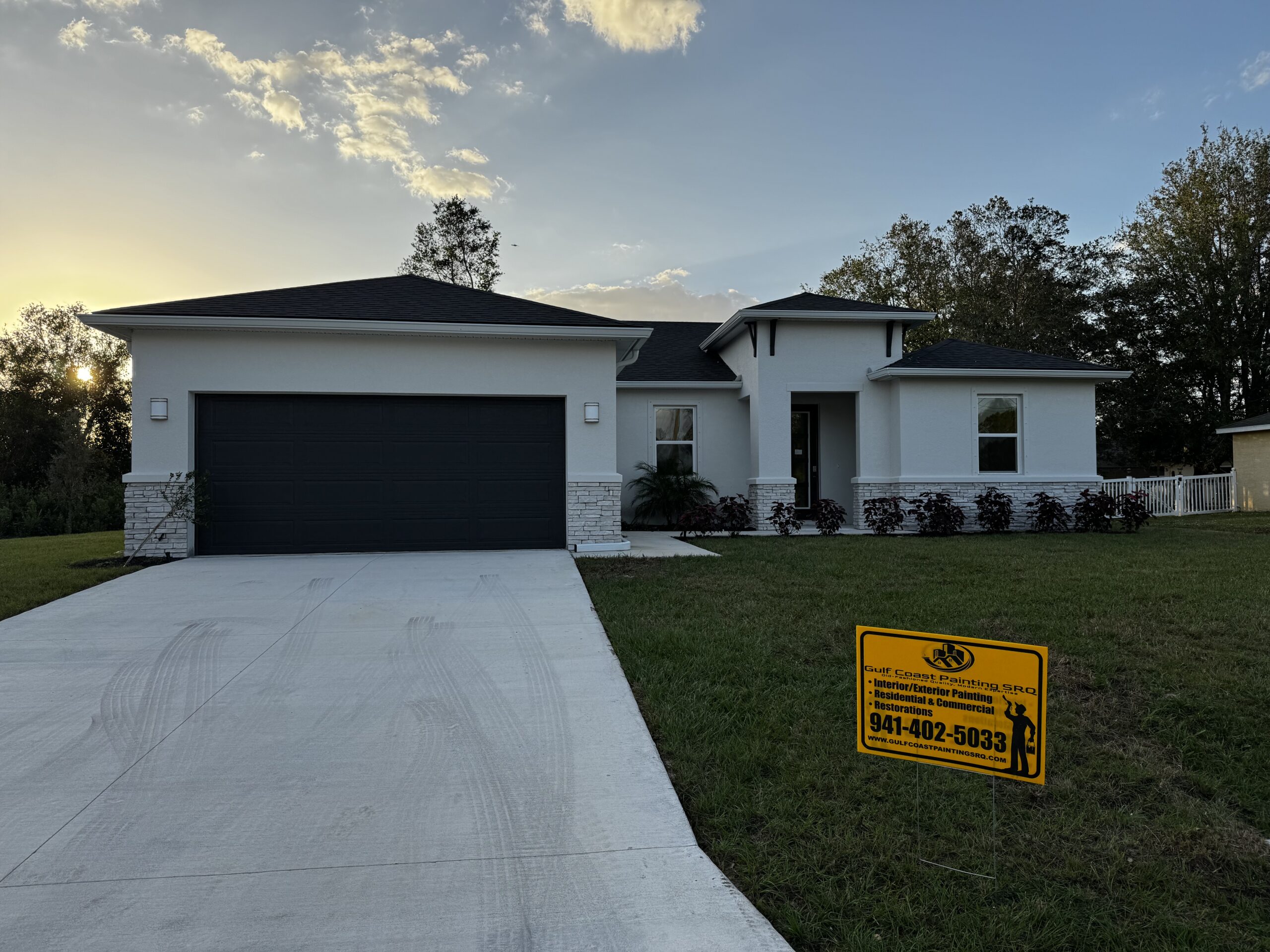 Sunlit exterior of a renovated Venice, Florida home with a modern white paint job and white accents, emphasizing high-quality painting work