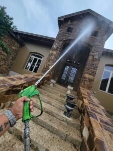 Gulf Coast Painting SRQ soft washing a house in Florida, showcasing professional exterior cleaning services.