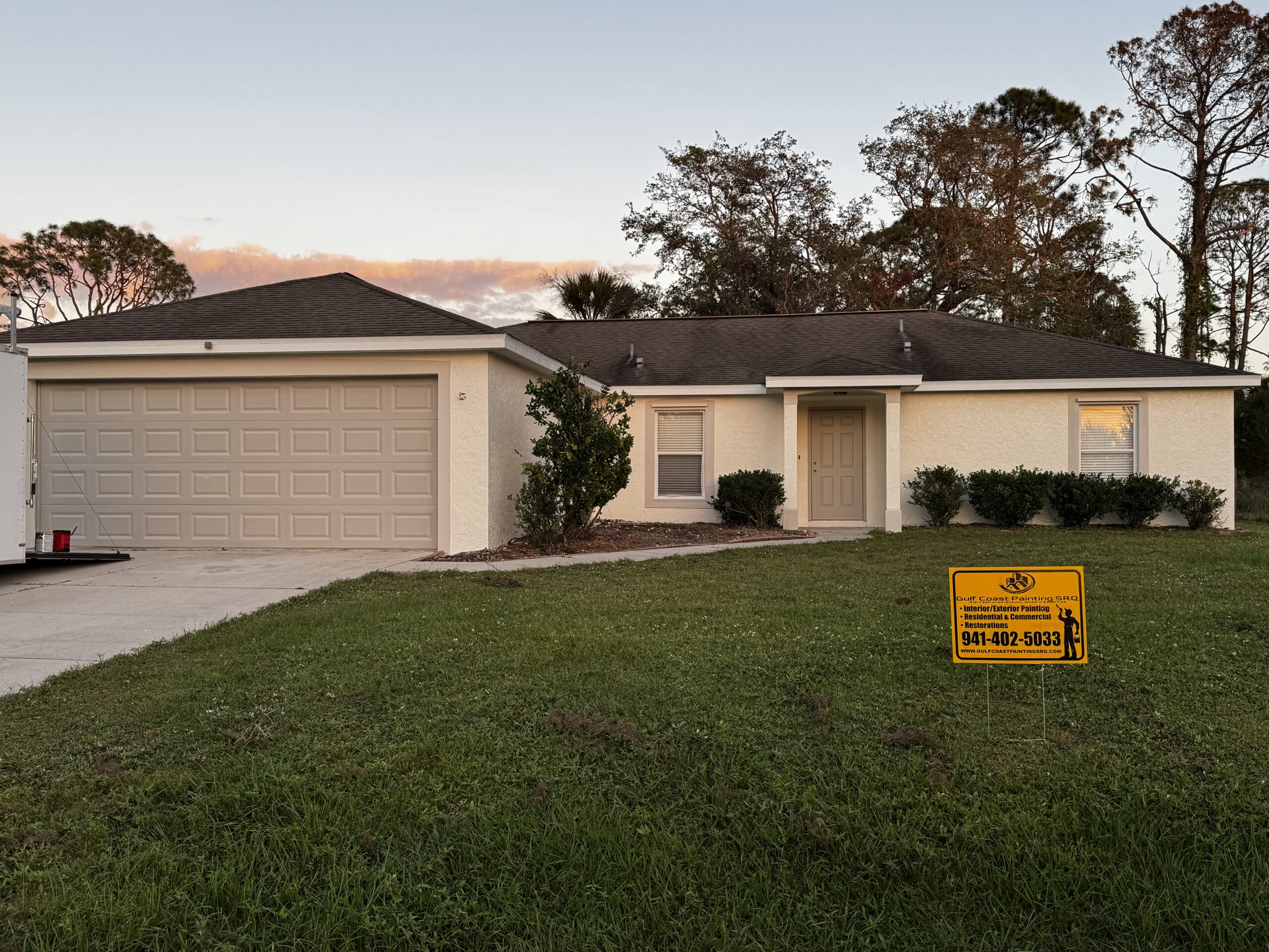 Freshly painted exterior of a coastal-style home in Venice, Florida, featuring a crisp white finish with gray trim, showcasing professional painting craftsmanship.